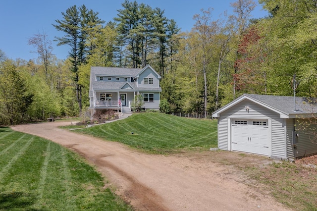view of front of home featuring dirt driveway, covered porch, a front yard, a forest view, and a garage
