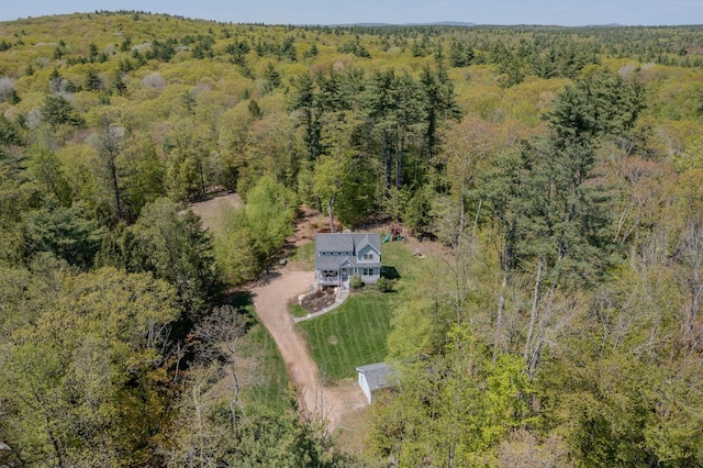 aerial view of property and surrounding area with a heavily wooded area