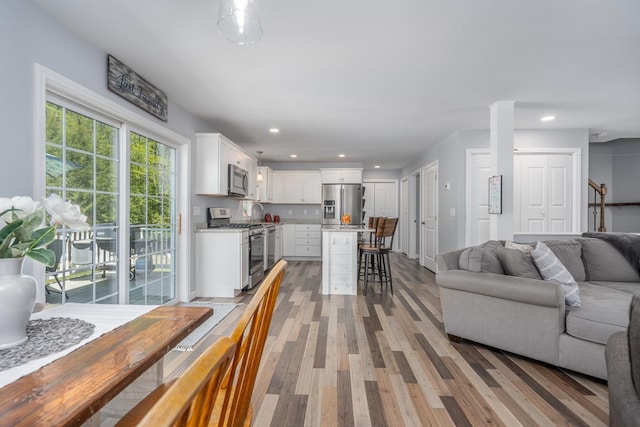 living room with light wood-style floors and recessed lighting
