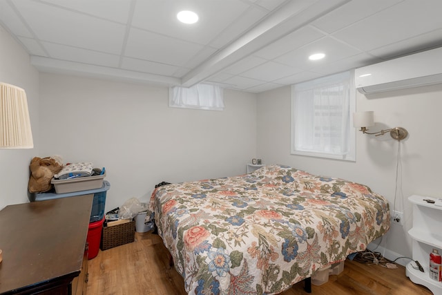 74 Pine St, Rollinsford, NH 03869 - bedroom with wood finished floors, a wall mounted AC, and a paneled ceiling