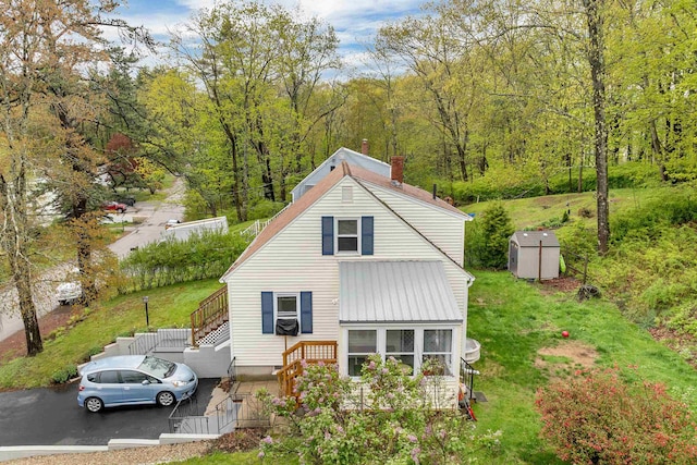 74 Pine St, Rollinsford, NH 03869 - back of property with a chimney, stairs, a storage unit, a forest view, and metal roof