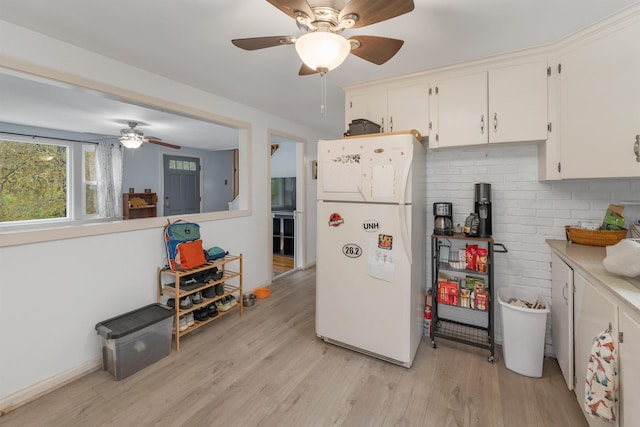74 Pine St, Rollinsford, NH 03869 - kitchen with freestanding refrigerator, ceiling fan, light wood-style flooring, light countertops, and white cabinets