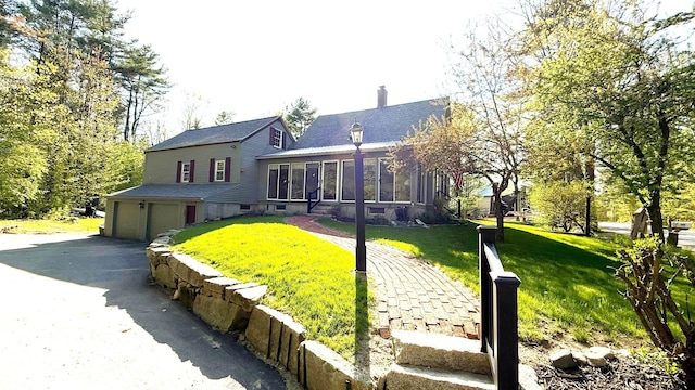 171 Stoneham Rd, Wakefield, NH 03872 - back of property with a garage, a sunroom, a chimney, a lawn, and a shingled roof