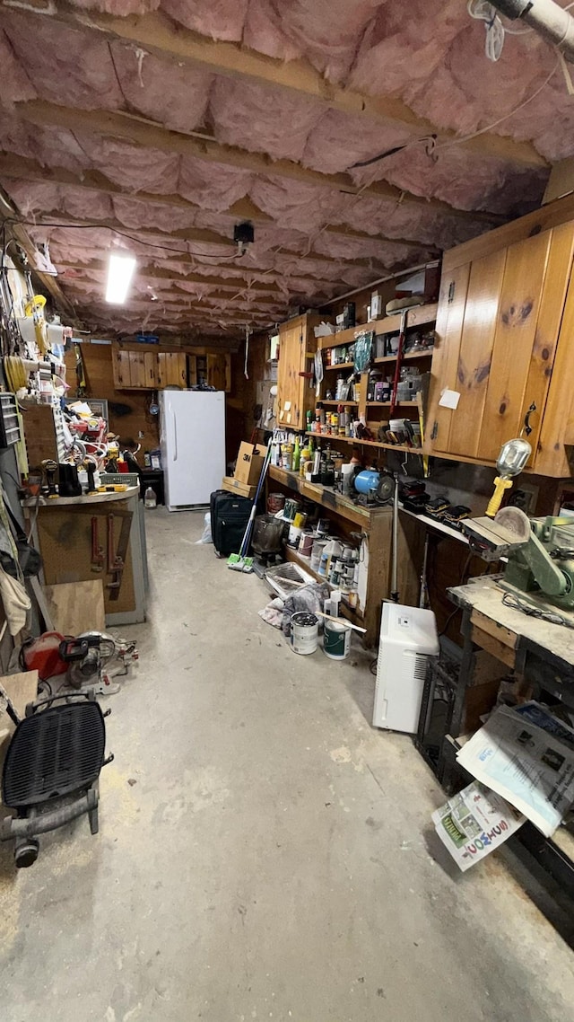 171 Stoneham Rd, Wakefield, NH 03872 - basement with a workshop area and freestanding refrigerator