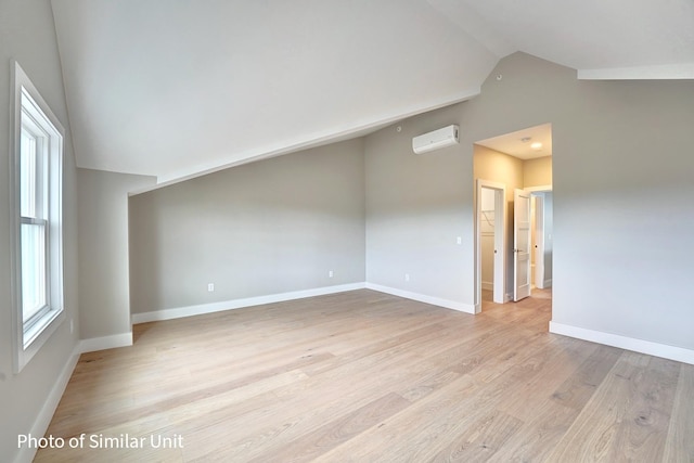 4 Fowler Dr, Rye, NH 03870 - unfurnished room featuring vaulted ceiling, an AC wall unit, light wood-style flooring, and baseboards