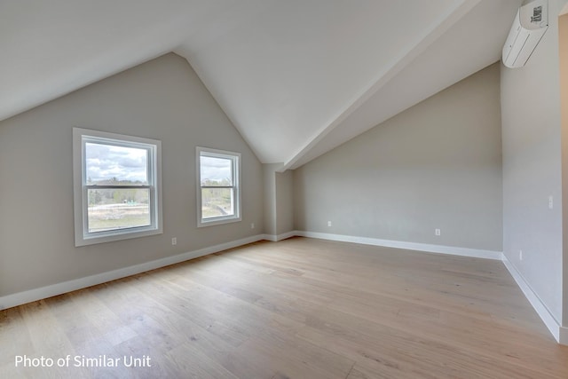 4 Fowler Dr, Rye, NH 03870 - additional living space with a wall mounted AC, light wood-style floors, vaulted ceiling, and baseboards