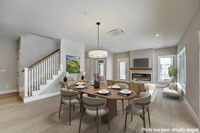 4 Fowler Dr, Rye, NH 03870 - dining area featuring a glass covered fireplace, wood finished floors, stairway, baseboards, and recessed lighting