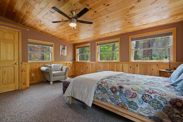 bedroom with lofted ceiling, wood walls, wooden ceiling, a wainscoted wall, and carpet flooring