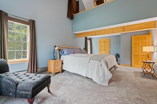 bedroom with carpet, a towering ceiling, and baseboards