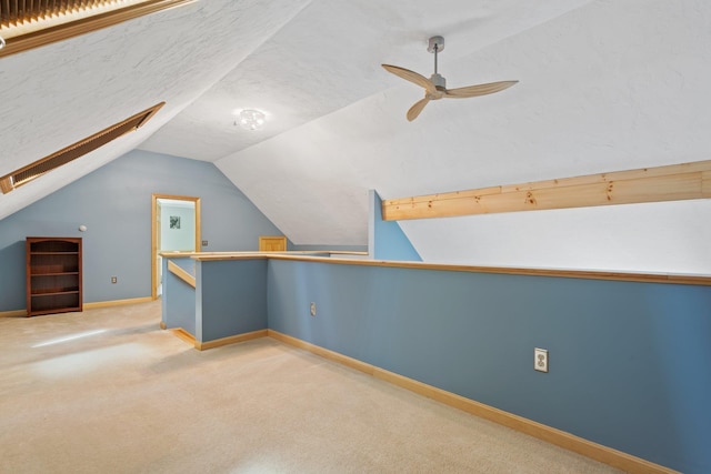additional living space with vaulted ceiling, carpet floors, baseboards, and a ceiling fan