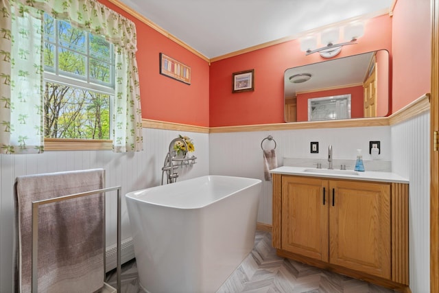 full bath featuring a wainscoted wall, a soaking tub, vanity, and crown molding