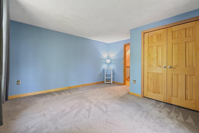 unfurnished bedroom featuring carpet and baseboards
