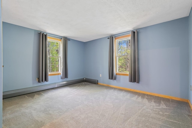 empty room with carpet floors, baseboards, healthy amount of natural light, and a textured ceiling