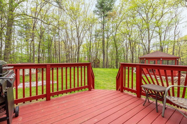 wooden deck with an outdoor structure and a lawn