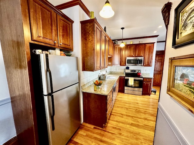98 Pennacook St, Manchester, NH 03102 - kitchen featuring stainless steel appliances, light wood-style flooring, tasteful backsplash, and light stone countertops