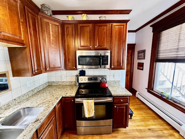 98 Pennacook St, Manchester, NH 03102 - kitchen with stainless steel appliances, a baseboard heating unit, tasteful backsplash, light wood-style floors, and light stone countertops