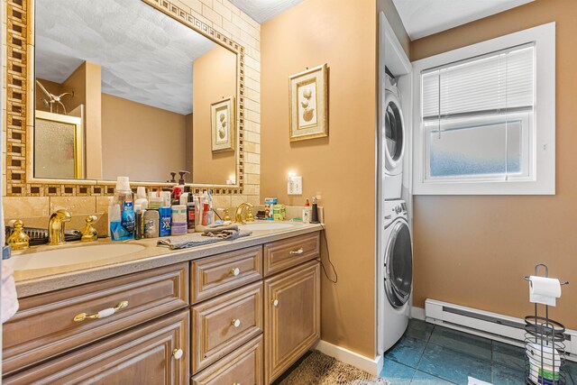 17 Dyson Dr, Salem, NH 03079 - bathroom featuring stacked washer / dryer, double vanity, an enclosed shower, baseboards, and baseboard heating