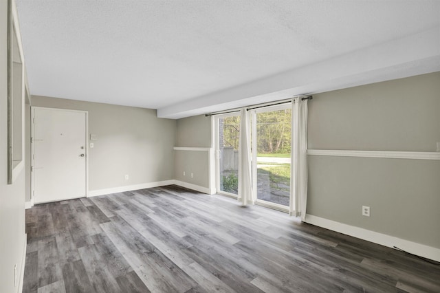 unfurnished room featuring wood finished floors and baseboards