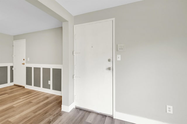 foyer entrance with wood finished floors and baseboards