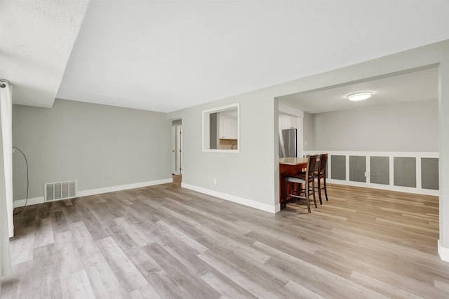 living room featuring light wood-type flooring and baseboards
