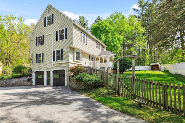 view of home's exterior featuring a garage, driveway, a storage unit, and stairway