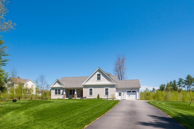 view of front of property featuring an attached garage, driveway, a front yard, and board and batten siding