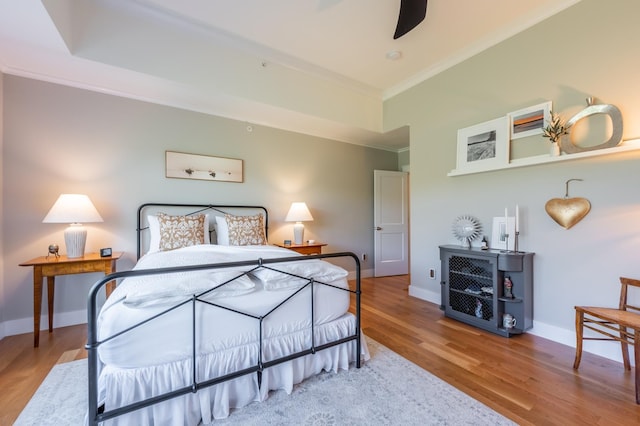 bedroom featuring ornamental molding, wood finished floors, and baseboards