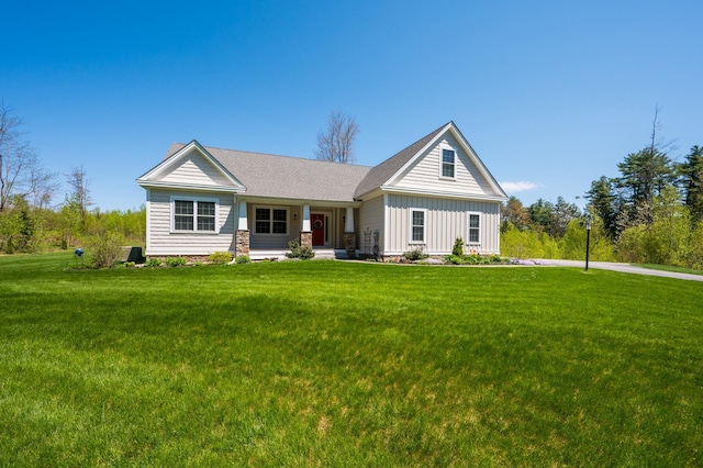 view of front facade featuring covered porch, a front lawn, and board and batten siding