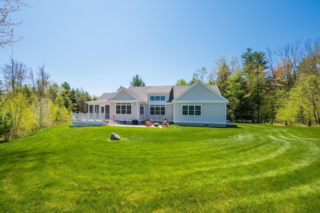 rear view of house featuring a yard and a deck