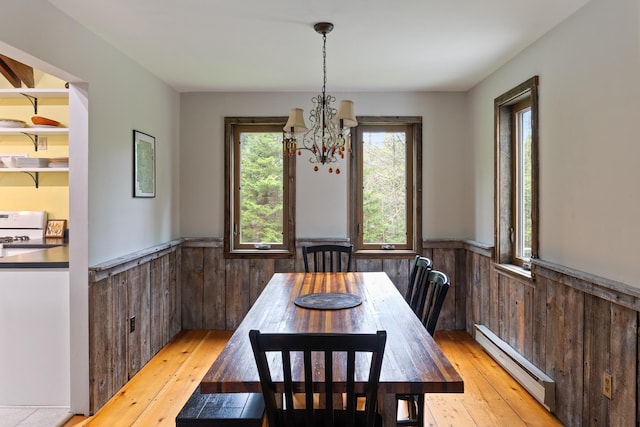 67 Birch Tree Ln, Fayston, VT 05673 - dining area featuring a baseboard radiator, wainscoting, a chandelier, light wood finished floors, and wood walls