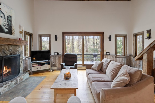 67 Birch Tree Ln, Fayston, VT 05673 - living room featuring a fireplace, a high ceiling, light wood-style floors, a baseboard radiator, and a baseboard heating unit