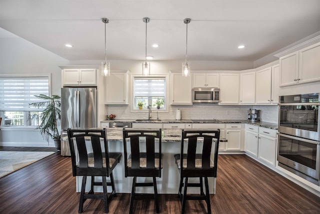 20 Del Ray Dr, Windham, NH 03087 - kitchen with appliances with stainless steel finishes, dark wood-style flooring, a kitchen bar, and recessed lighting