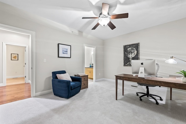 office featuring light colored carpet, ceiling fan, baseboards, and vaulted ceiling