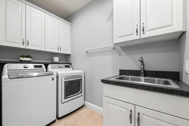 washroom featuring washer and dryer, cabinet space, and baseboards
