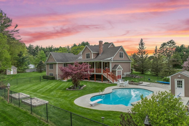 view of pool with a shed, an outbuilding, a diving board, stairs, and a patio area