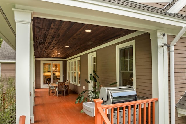 wooden deck featuring covered porch and area for grilling