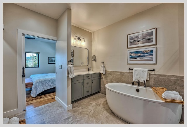 full bathroom with vanity, a freestanding bath, and ensuite bathroom