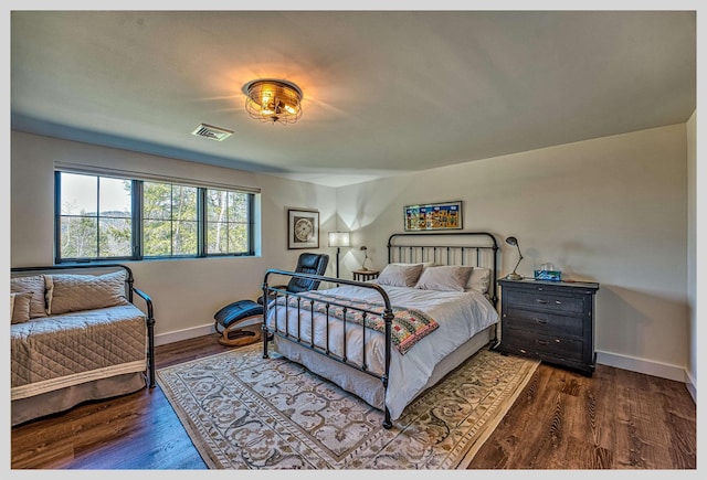 bedroom featuring dark wood-style flooring and baseboards
