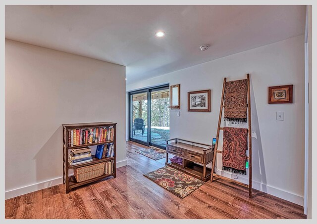 living area with wood finished floors, baseboards, and recessed lighting