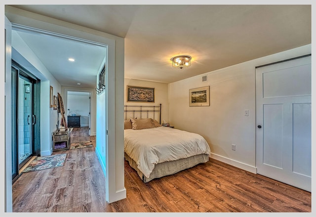 bedroom with wood finished floors and baseboards