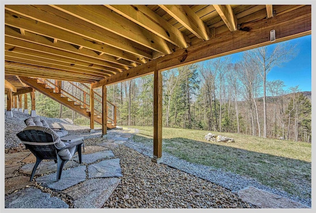 view of patio / terrace featuring stairway and a view of trees