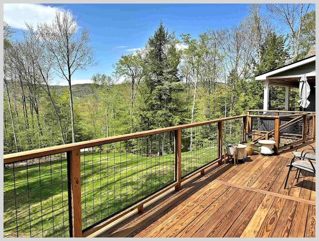 deck featuring a yard and a forest view