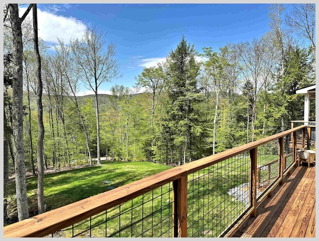 deck featuring a yard and a view of trees