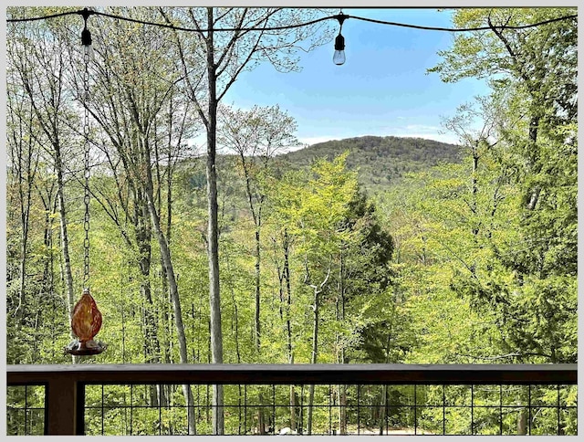 view of mountain backdrop featuring a forest