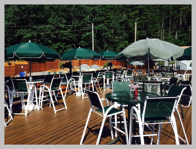 wooden terrace with outdoor dining area and fence