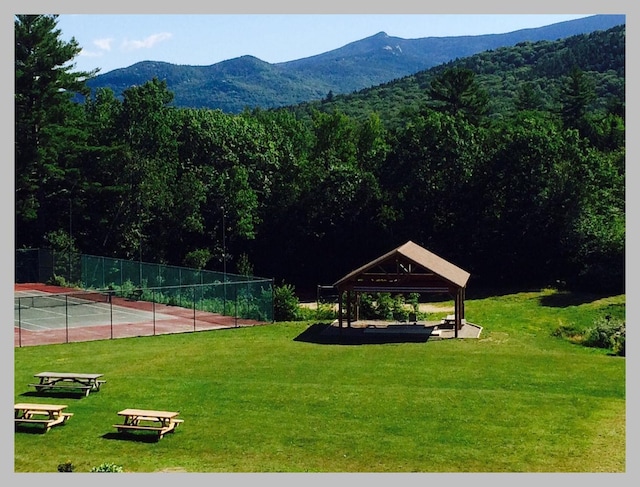 view of home's community featuring a gazebo, a mountain view, a tennis court, and a forest view
