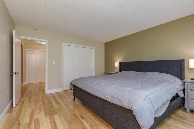 bedroom featuring light wood-type flooring, a closet, and baseboards