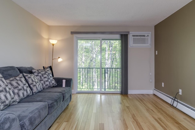 living area with a baseboard radiator, a wall mounted AC, light wood-type flooring, and baseboards