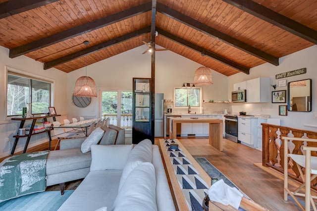 living area featuring wooden ceiling, light wood-type flooring, high vaulted ceiling, beamed ceiling, and ceiling fan