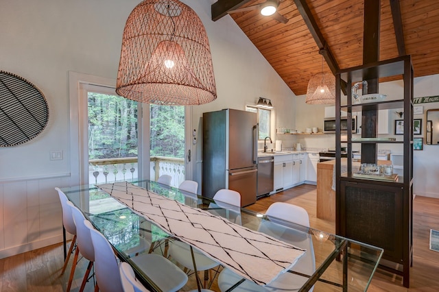 dining area featuring high vaulted ceiling, beam ceiling, light wood finished floors, wood ceiling, and a chandelier